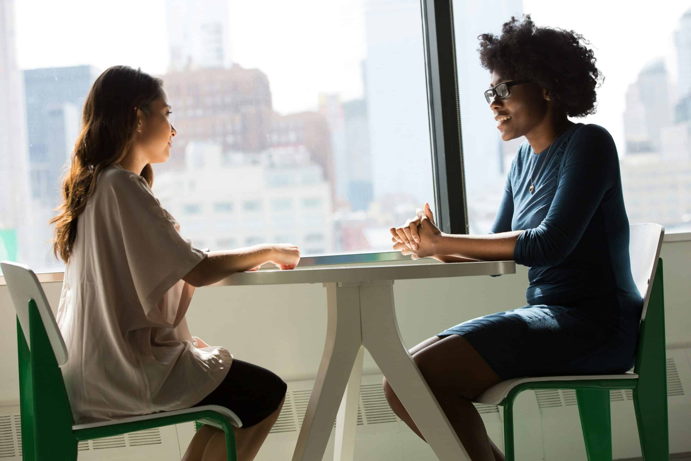 Prospective egg donor discussing filling out an online donor application with a friend